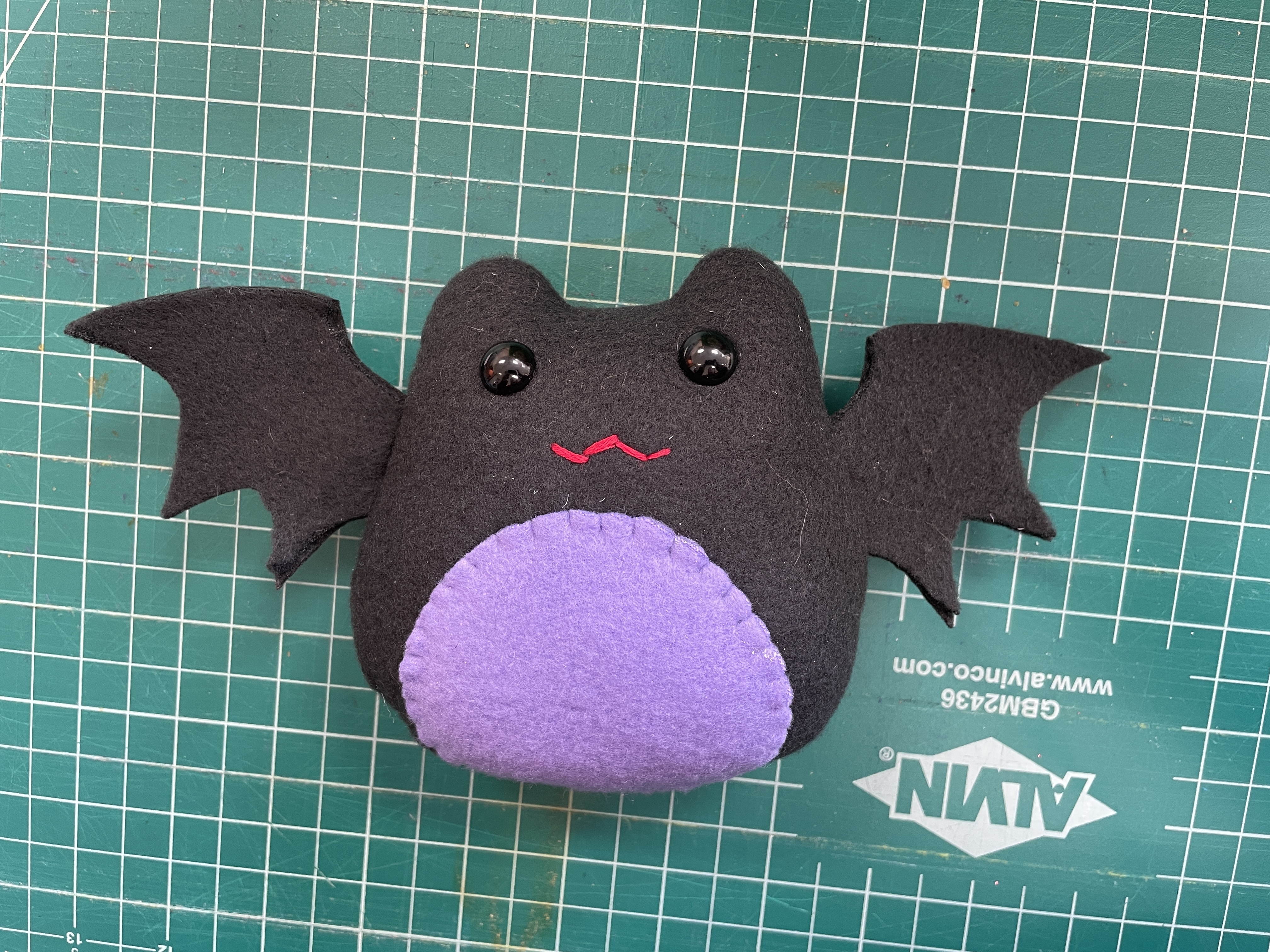 bat stuffed animal on green background