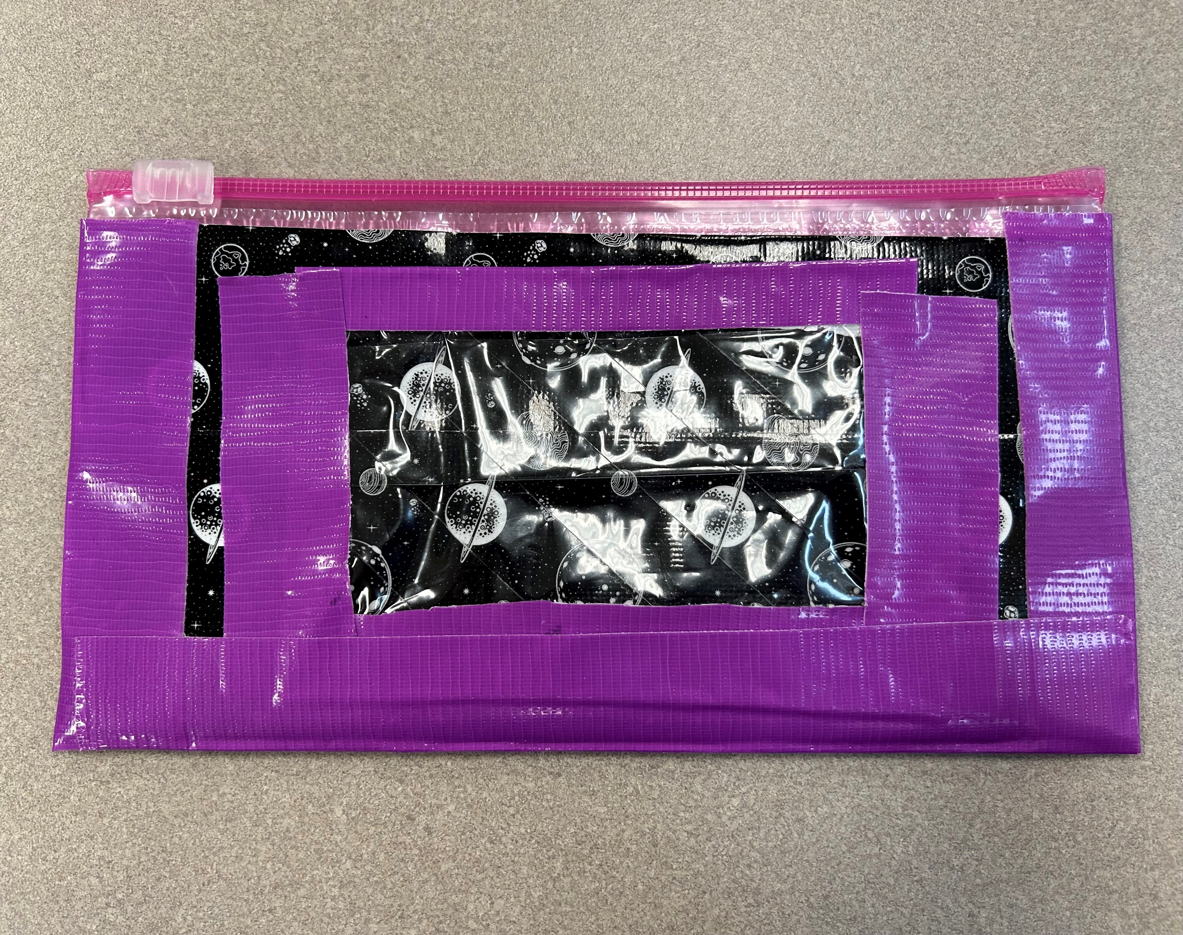 A photo of a finished duct-tape pencil case, with a sliding opening at the top, and a transparent space for an ID or library card in the front.
