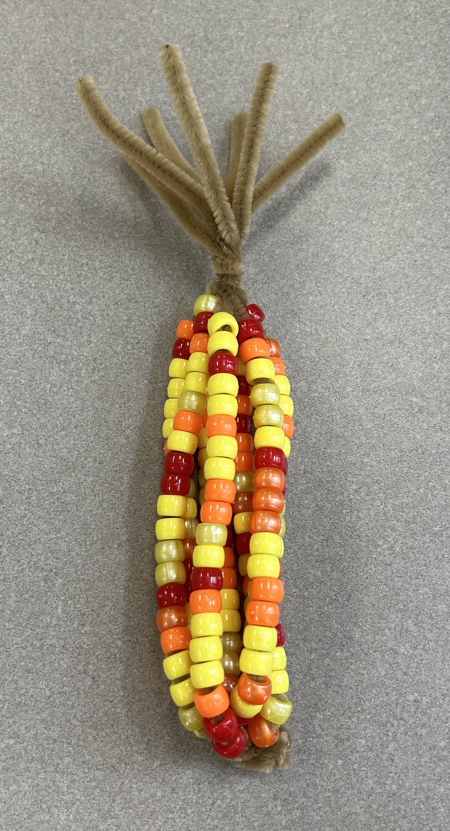 Pony beads assembled on pipe cleaners twisted together to look like an ear of corn