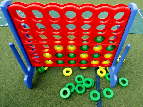 Large connect four game set with yellow and green pieces