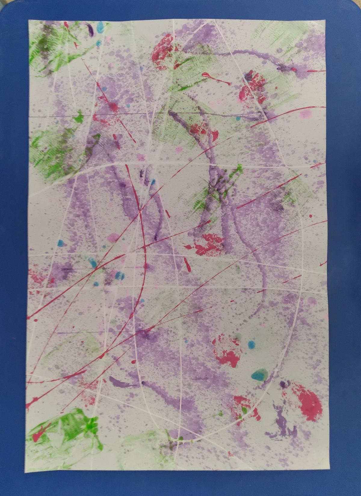 Large paper with splatters of different colors of paint