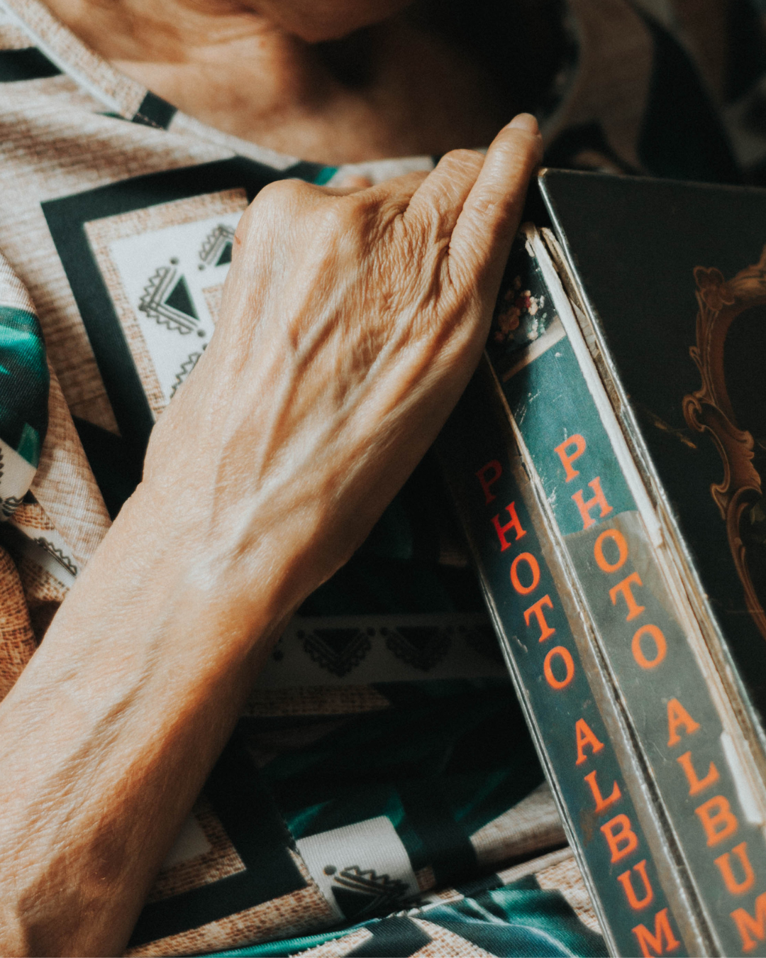 Close-up of older woman holding two photo albums. 