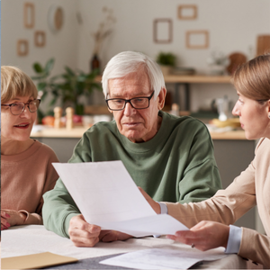 Three adults seated at a table reviewing paperwork.